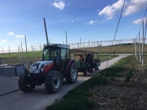 Hier ist ein Bild eines Traktor mitsamt den Helfern.